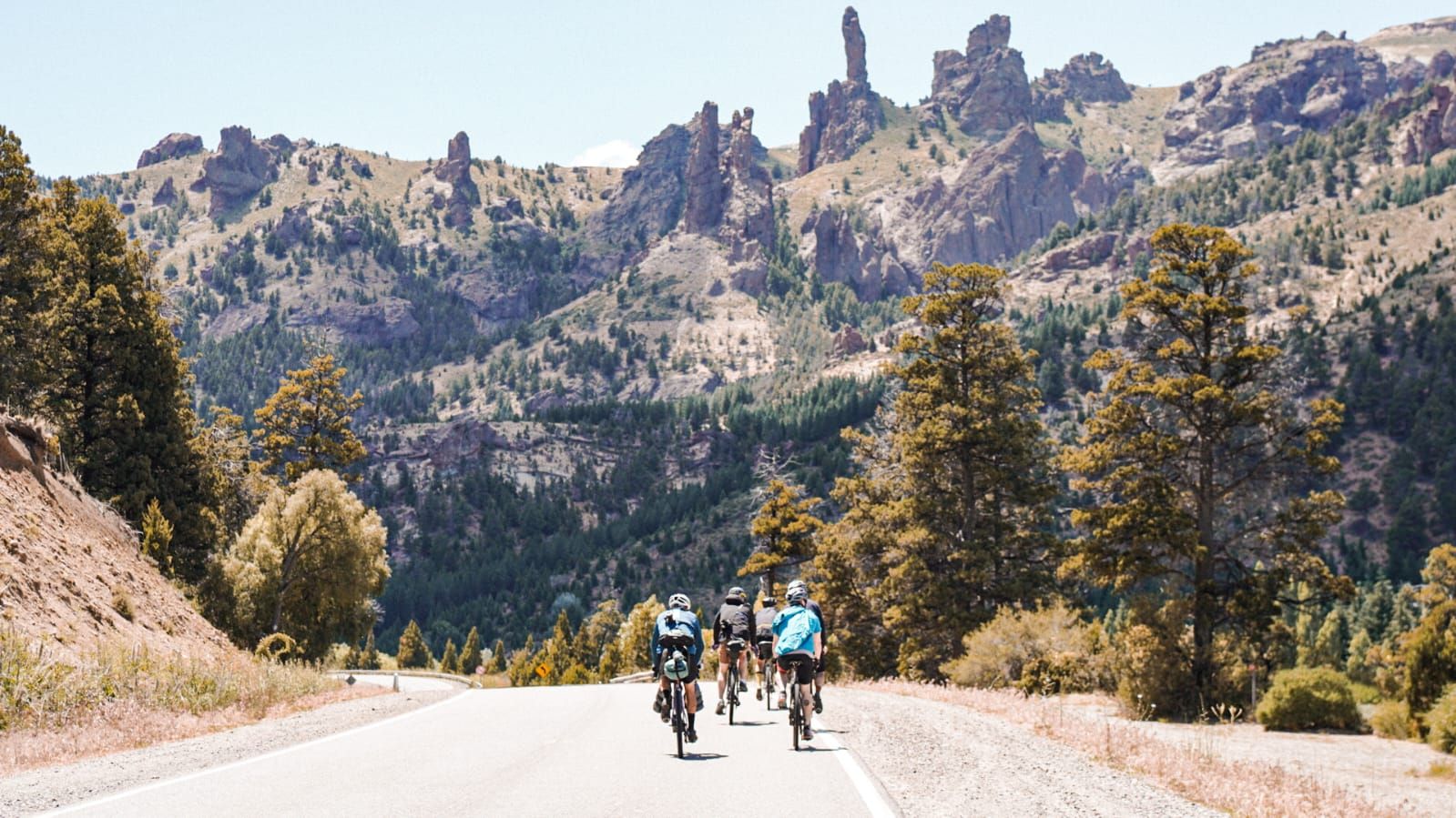 Riders on a road below rock towers in Patagonia